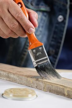 closeup the man hand using paintbrush to painting the wood plank