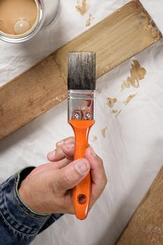 closeup the man hand using paintbrush to painting the wood plank