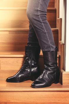 young woman wearing black leather boots. Fashion black leather boots with zip.