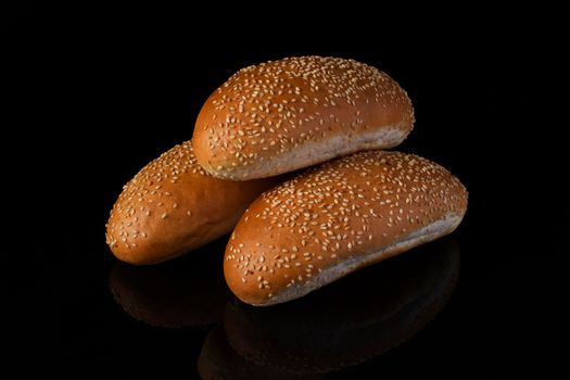 Buns with sesame seeds on a dark background.Loaf