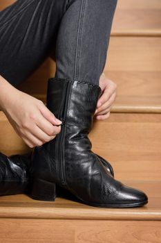 young woman wearing black leather boots. Fashion black leather boots with zip.