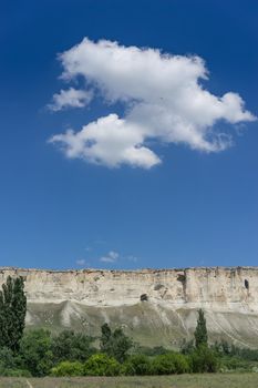 Landscape overlooking the white rock in the Crimea, against the blue sky with clouds.