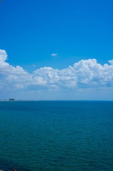 Seascape with water surface and sky with clouds.
