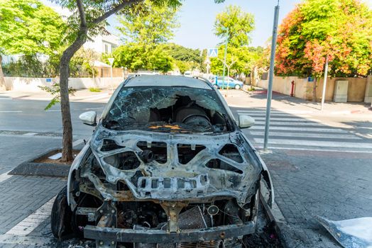 Burned car close up. Car after the fire, crime of vandalism, riots. Arson car. Accident on the road due to speeding. Explosion. High quality photo