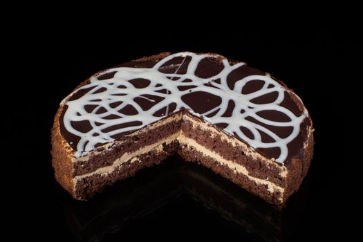 A slice of chocolate cake with white icing on a black background