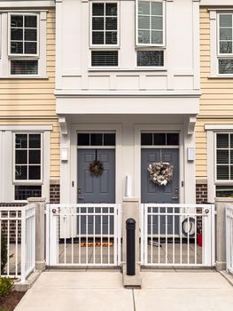 Entrance doors of brand new residential townhouses with metal gate in front