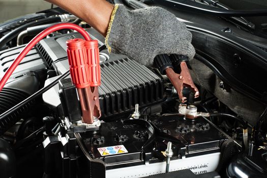 car battery with jumper cable in engine room, car repairing concept