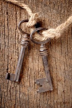 bunch of vintage keys with rope on old wooden plank