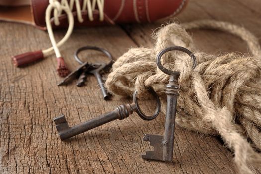 bunch of vintage keys with rope on old wooden plank