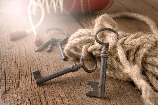 bunch of vintage keys with rope on old wooden plank