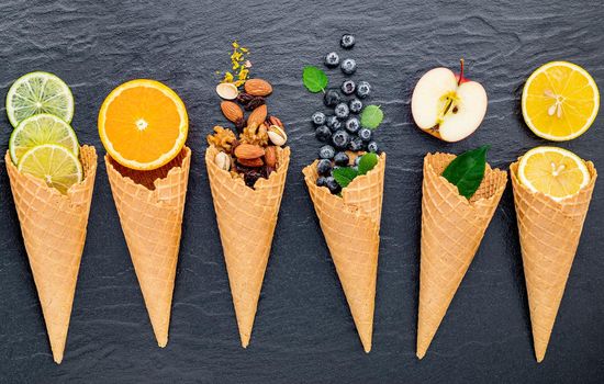 Various of ingredient for ice cream flavor in cones  set up on dark stone background . 