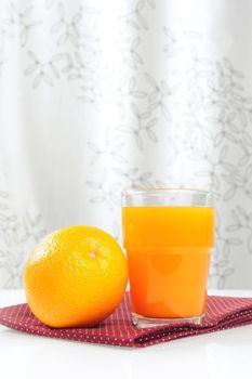 Ripe orange and cup of orange juice