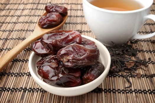 closeup sweet dried dates fruit with tea