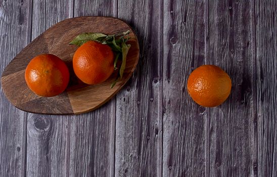 Various oranges on wooden table on dark wooden floor