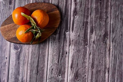 Various oranges on wooden table on dark wooden floor