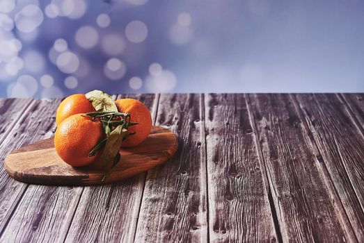 Various oranges on wooden table on wooden floor and bright background
