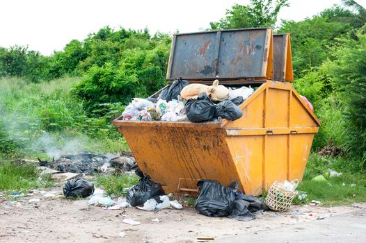 yellow dumpster with household garbage