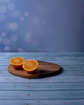 Orange cut in half on wooden board on wooden background and bright background