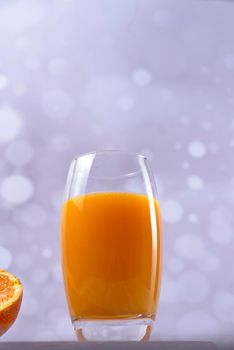 Large glass of orange juice, bright background, front view