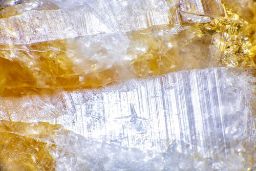 macro shooting of natural rock specimen. Raw crystal of Citrine yellow quartz gemstone from Brazil. Shimmering gold background. High quality photo