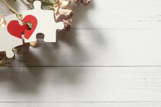 Red heart is drawn on the pieces of the puzzle lying next to each other on white background. Love concept. Divorce