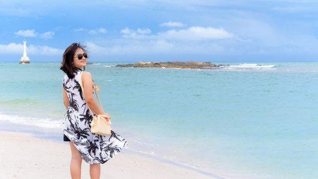 Beautiful nature landscape of the beach and sea in summer sky and cheerful woman tourist wearing sunglasse smiling with happiness on Tarutao island, Satun, Thailand, 16:9