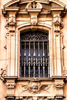 Window and carved stone details of the main facade of the Cathedral of Murcia.