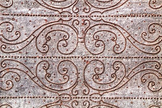 Old gray metal door of a church with wrought iron details in Murcia, Spain