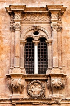 Window and carved stone details of the main facade of the Cathedral of Murcia.
