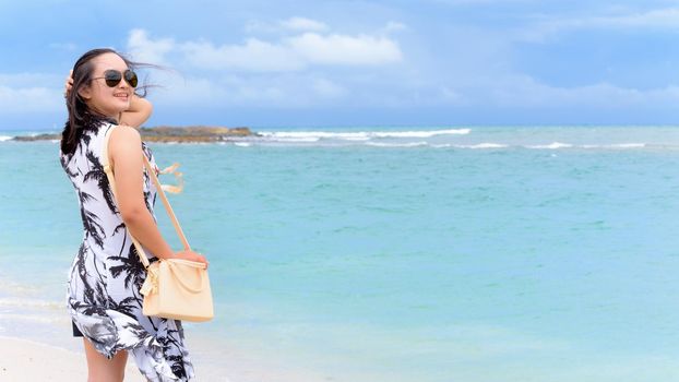 Beautiful nature landscape of the beach and sea in summer sky and woman tourist wearing sunglasse smiling with happiness on Tarutao island, Satun, Thailand, 16:9 widescreen