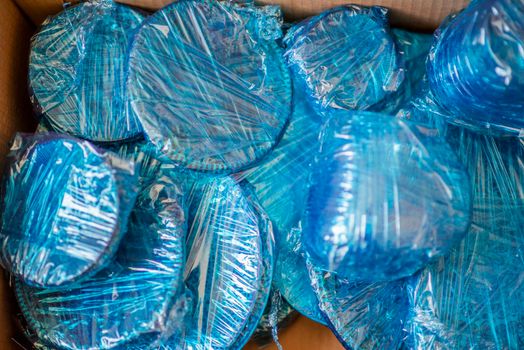 Glassware wrapped with blue wrapping nylon at the bottom of a cardboard box. High quality photo