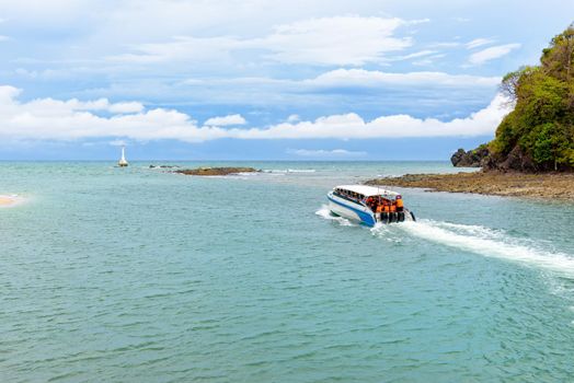 Tourists travel by speed boat, traveling on the sea leaving the coast of Tarutao island, beautiful nature in summer at Ko Tarutao National Park is a famous attractions of Satun Province, Thailand