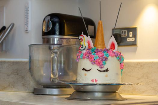 Close-up of a unicorn decorated birthday cake on a kitchen counter