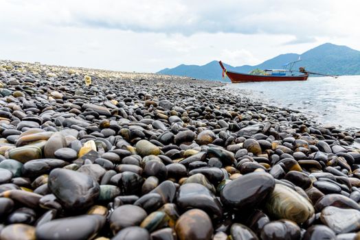 Beautiful nature landscape of rock with unusual black color and long tail boat trip floating in the sea at Ko Hin Ngam island is a famous tourist attractions of Tarutao National Park, Satun, Thailand