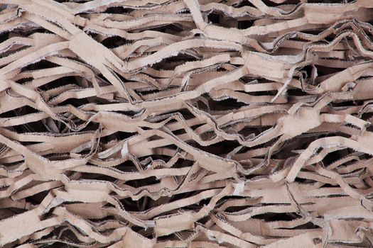 A shredded and crimped brown cardboard background texture