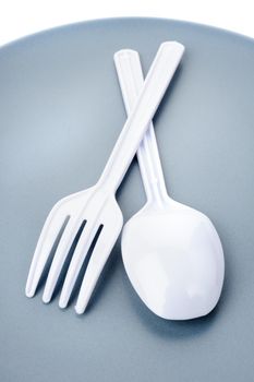 closeup plastic cutlery on plate