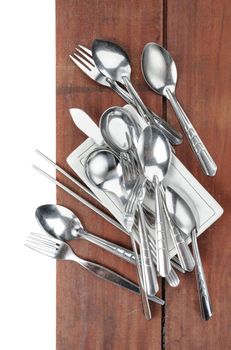 forks and spoons on wooden plank background