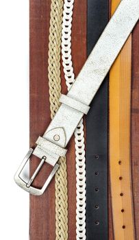 isolate leather belts on wooden plank