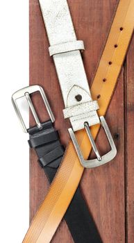 isolate leather belts on wooden plank