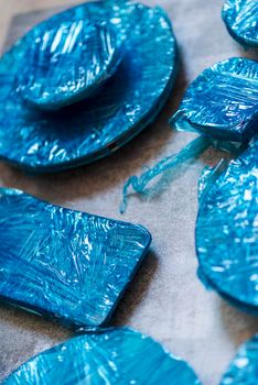 Small plates wrapped in blue cling film placed on brown wooden floor background. Top view. Copy Space. High quality photo