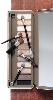 closeup makeup brush cosmetics on wooden plank background