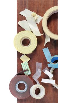 many type of adhesive tape on wooden plank, working background