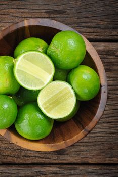 fresh green limes on wooden desk