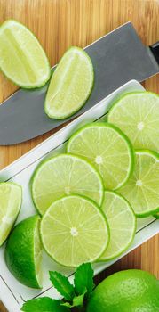 closeup sliced fresh green limes in white plate