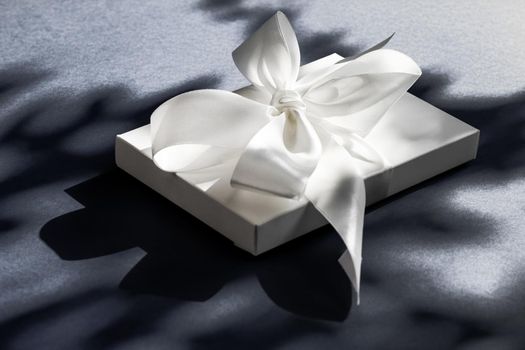 Anniversary celebration, shop sale promotion and luxe surprise concept - Luxury holiday white gift box with silk ribbon and bow on black background, luxe wedding or birthday present