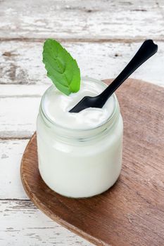 natural yogurt in glass on wooden plank, delicious natural yogurt 