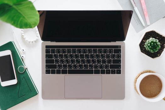 Top view of modern laptop or notebook with phone to work. Office desktop on table background.