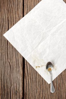 blank folded paper with teaspoon on wooden table
