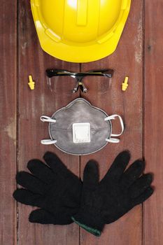 personal safety equipments on wooden plank arrange like human face