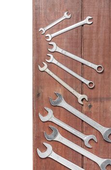 wrenches on wooden plank background